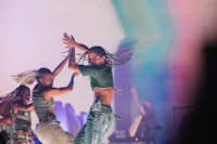 two dancers performing on stage in front of a colorful background