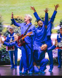 a group of people in blue outfits on stage
