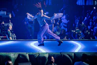 a woman is performing on a stage in front of a crowd